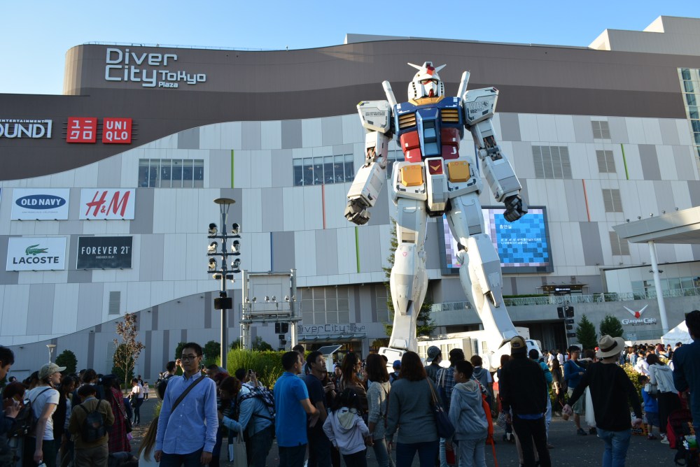 Hundreds gather to witness this gundam robot's first test flight. No video unfortunately, out of battery